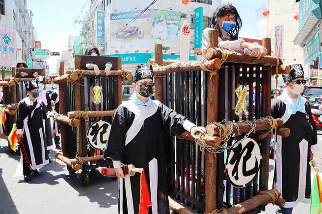 夜巡遶境中有古代犯人囚车、头镣手铐、城隍庙刽子手百年大刀、衙役、神轿，队伍人员将拿传统火把在遶境队伍中驱逐魑魅。（吕妍庭摄）