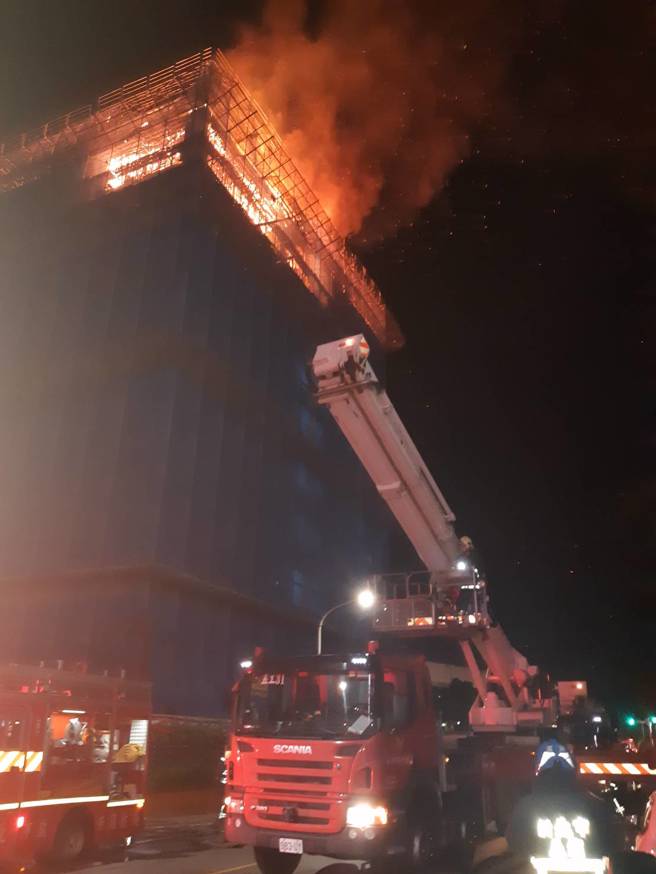 新北市三重1处工地大楼，「9至10楼全面燃烧」消防人员登云梯车灌救。（新北消防局提供）