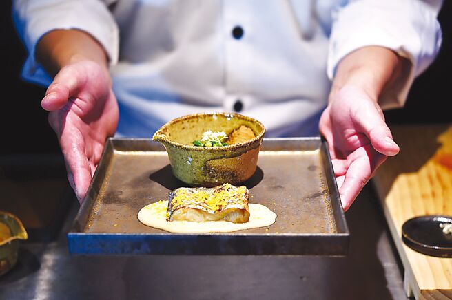 〈太刀鱼／干贝／甜豆／接骨木花〉是以油脂丰厚的白带鱼以炭火炙烤并现刨乌鱼子粉提味，配菜有紫苏花、飞鱼卵、盐昆布。图／姚舜