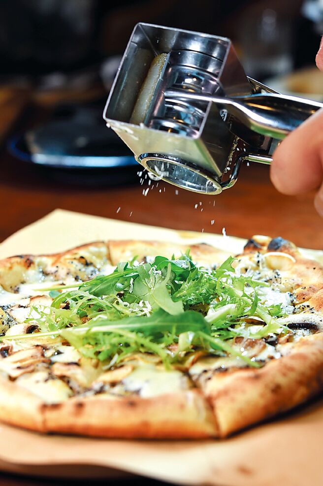 〈松露野菇披萨〉服务人员会现刨起司提味。图／姚舜