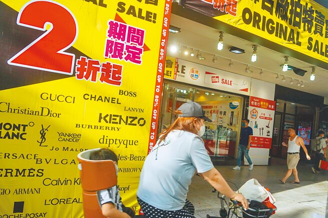 国发会昨公布7月景气灯号，续亮第五颗代表「稳定」的绿灯。不过，景气领先、同时指标续呈下跌，景气对策信号综合判断分数大减3分、为24分，是2020年8月以来近两年新低。图为台北市中山区店面短期出租给临时特卖会。（中央社）