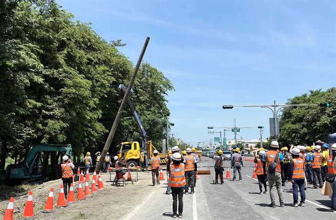 屏鹅公路种树百里工程，成功拔除首支电杆，工程人员纷纷拿出手机记录这重要里程碑。（台电提供／林和生屏东传真）