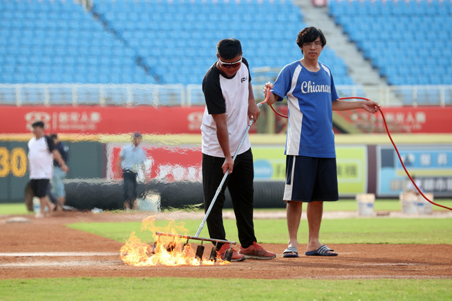 乐天桃猿「阿迷趴」最终日赛前下起午后雷阵雨，工作人员出动喷枪加速场地乾燥。（陈麒全摄）