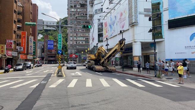 台北市文山区景中街、景后街口28日发生一辆曳引车转弯时撞倒号志灯杆事件，幸未酿伤亡，警方获报到场处理发现，为附载挖土机伸缩臂超长所致。（图/ 中央社）