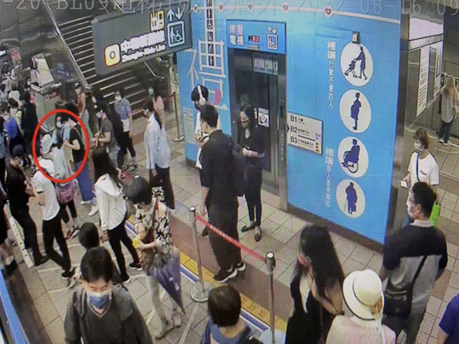 松鼠爬到饲主身上（饲主蓝衣服）。(捷运警察队提供)