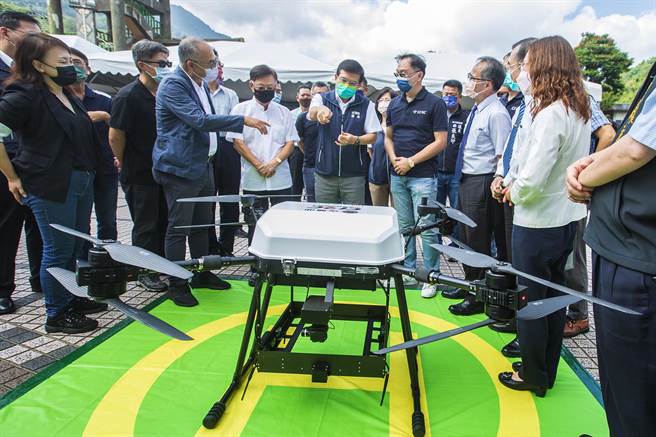 交通部长王国材（中）指在尖石试飞的无人机，是台湾第1架能载货25公斤的无人机。（罗浚滨摄）