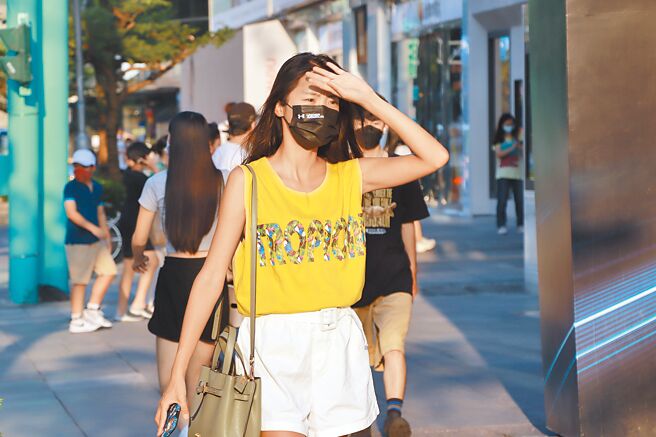 中央氣象局指出，台灣在太平洋高壓邊緣，天氣炎熱高溫飆至37、38度，提醒民眾注意防曬、防中暑。夏日午後，民眾至信義街頭逛街，以手遮擋頭上刺眼陽光。（實習攝影記者謝家瑀攝）