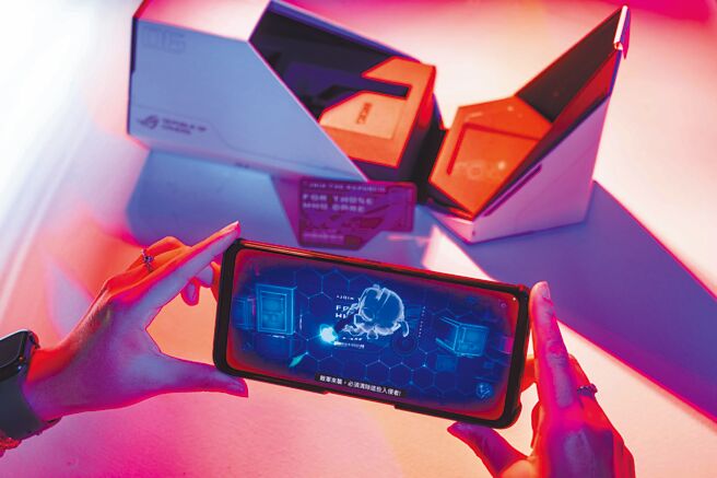 ROG Phone 6 Pro此次延续如太空舱般的柱型盒装包装，机身则採极光白色设计，具备6000mAh超大容量电池，「平常开实况直播时需要插上转接头，但一般手机连接孔都在下方，横向手持时会容易折到或卡到线，插孔在中间的话，手指才不会卡到超方便！」，而且更随附ROG卡片（见图），能在设定时体验AR互动去了解手机，也是小巧思之一。