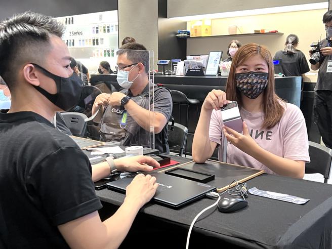 今日（30日）抢到头香的民眾徐小姐深受Galaxy Z Flip4夜拍功能及电池续航升级所吸引，因此决定入手换机。（石欣蒨摄）