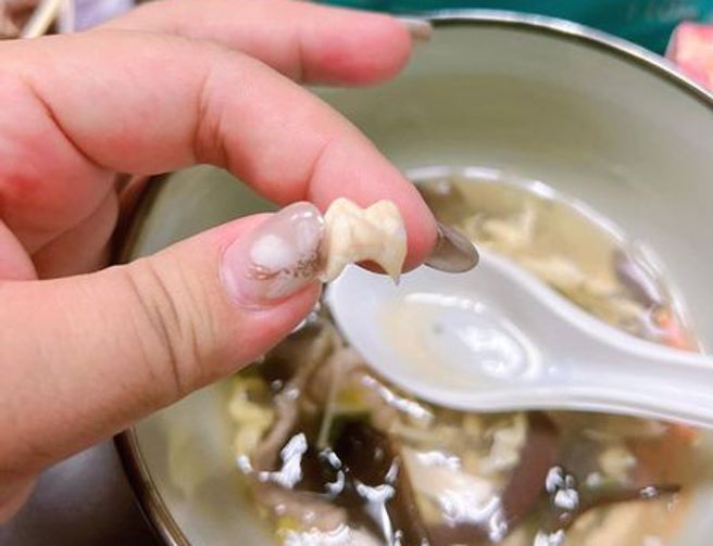 她喝酸辣汤喝到假牙，网友们见状傻眼直呼：「妈呀⋯爆炸噁烂」。（图／爆怨公社）