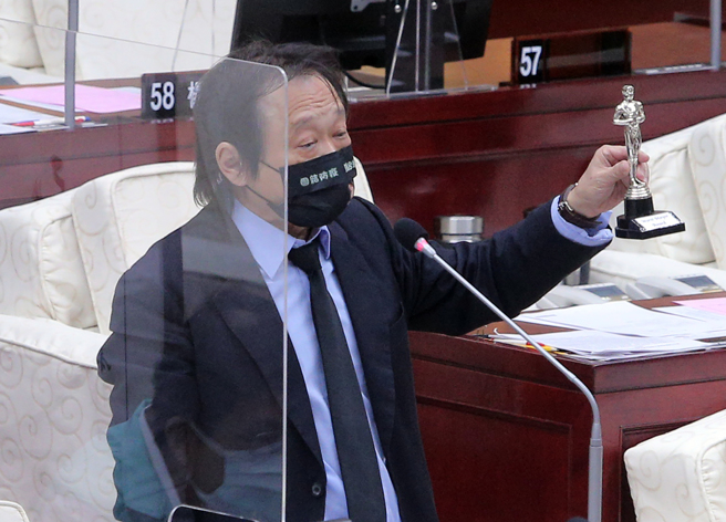 民進黨台北市議員王世堅（見圖）30日在市議會質詢市長柯文哲時，表示調閱柯文哲上任8年內，治安、消防安全、交通安全等數據，都創下民選市長以來最壞的紀錄，因此特地送上金酸莓小金人，要頒發「最差市長獎」給柯文哲。（趙雙傑攝）