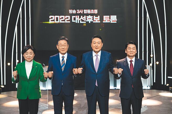 图为共同民主党新任党魁李在明（左二）与韩国总统尹锡悦（左三）在2月的韩国总统大选电视辩论前合影。（新华社）