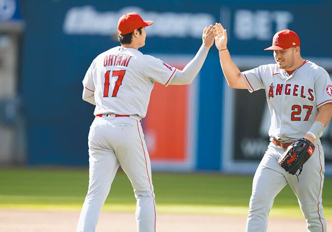 大谷翔平（左）与卓奥特同场炮轰蓝鸟，两人在获胜后击掌庆祝。（路透）