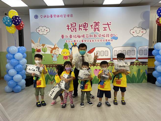 台鐵局於台北車站設置職場互助教保服務中心，交通部長王國材（後）與小朋友合影。（陳祐誠攝）