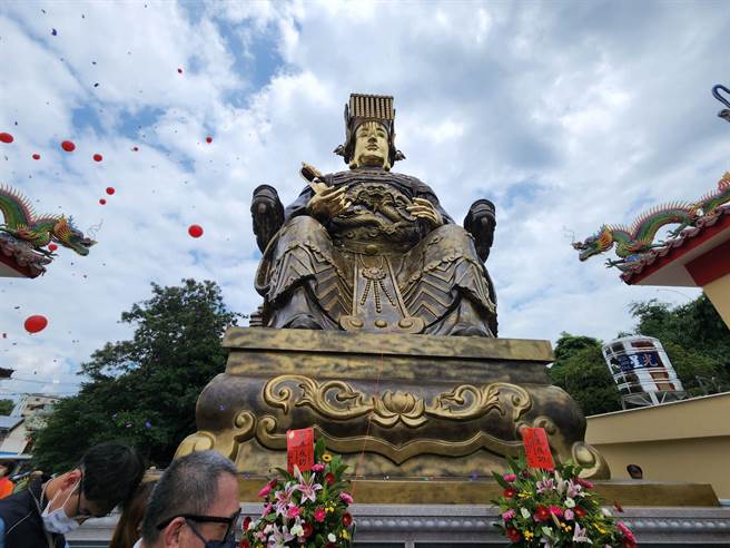 号称「全球最大的纯铜铸妈祖神像」31日在南投草屯朝清宫完成安座仪式，庙方人员请来吊车将道士挂上4层楼高的妈祖上面，进行开光仪式。(吴建辉摄)