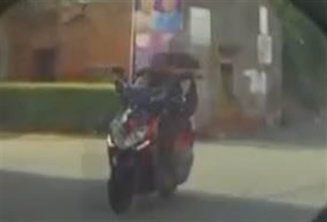 鹿港頂草路出現翹二郎腿騎士，把雙腳當雙手掌控機車方向手把，雙手閒來玩手機。（彰化縣媒體記者爆料網／吳敏菁彰化傳真）