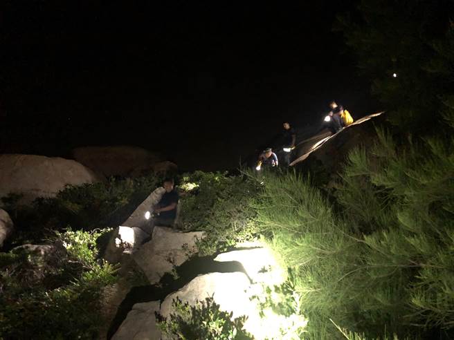 县消防局出动大批人力在崎岖山区搜索，天色昏暗十分困难。（ 金门消防局提供）