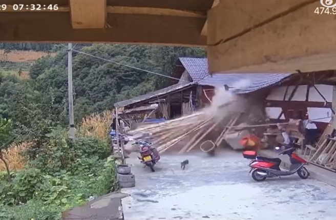 大陸有名老奶奶坐在庭院前，疑似發現有異狀，慢慢的走離開，不料，5秒後3噸重巨石砸穿民宅。（翻攝自微博）