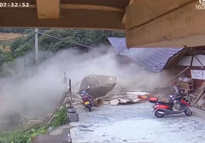 大陸有名老奶奶坐在庭院前，疑似發現有異狀，慢慢的走離開，不料，5秒後3噸重巨石砸穿民宅。（翻攝自微博）