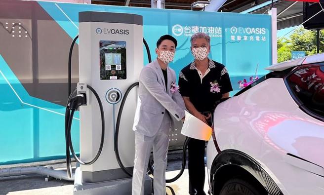 台糖中兴加油站与源点科技（EVOASIS）合作建置电动汽车充电站，台糖油品事业部副执行长林信志（右）与源点科技董事郑旭捷（左）一起为电动车充电。（图/ 中央社）
