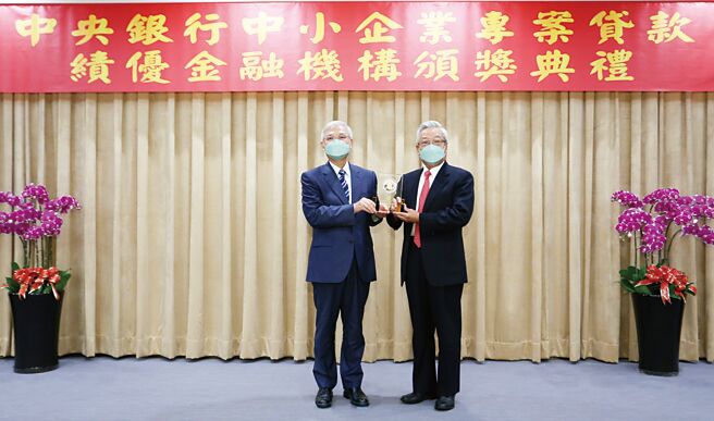 兆丰银行助中小企业商家纾困不遗余力，中央银行总裁杨金龙（左）颁发「绩效卓着奖」给兆丰银董事长张兆顺（右）。图／兆丰银行提供