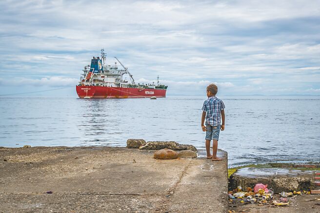 索羅門群島政府告知美方，將暫時不讓美國海軍艦艇進入索國港口。圖為索羅門群島首都荷尼阿拉，一名男孩望著海上的貨輪。（新華社）