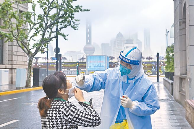 大陸持續清零政策，影響外商在陸投資。圖為上海福州路，醫護人員為市民進行核酸檢測採樣（中新社）