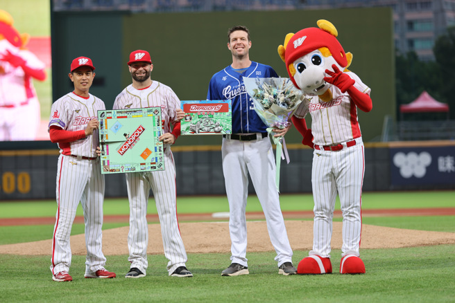 富邦悍将洋投罗力（右二）在2日迎来生涯最终战，1日赛前味全龙由队长吴东融献上花束、好友伍铎则送上特制桌游。（味全龙提供）