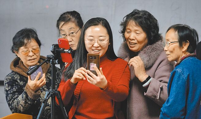 8月31日，中国互联网络信息中心（CNNIC）发布第50次《中国互联网络发展状况统计报告》显示，截至2022年6月，中国网民规模为10.51亿，互联网普及率达74.4％。图为太原老年开放大学教师杨晓琴（中）在智能手机课上教老年人使用手机上网。（中新社）