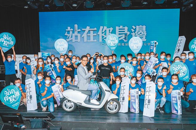 光捷总经理张森宪（中央骑车者）与经销商合照，并喊出「站在你身边」的服务宣言。（石智中摄）