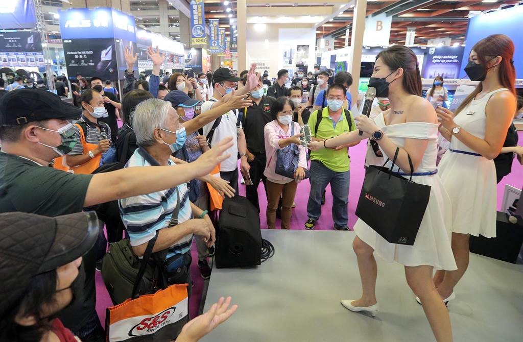 「2022台北3C電腦電玩電器空調影音展」2日在台北世貿一館登場，參展攤位請活動主持人發送小禮物，吸引人潮。（趙雙傑攝）