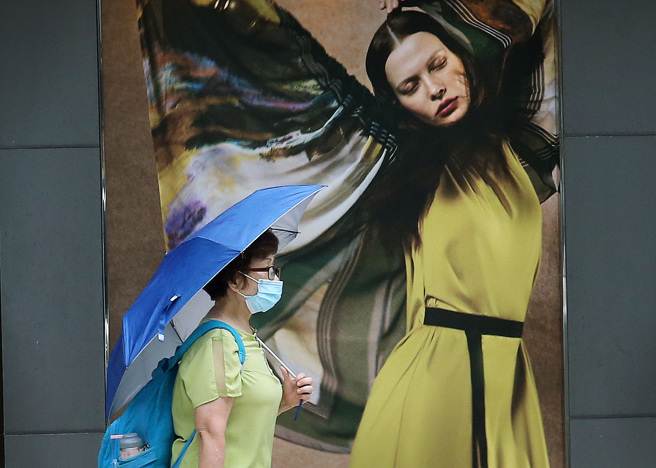 轩岚诺来袭，不排除陆警机率。大台北地区不时飘雨，街头行人纷纷撑起雨伞。（范扬光摄）