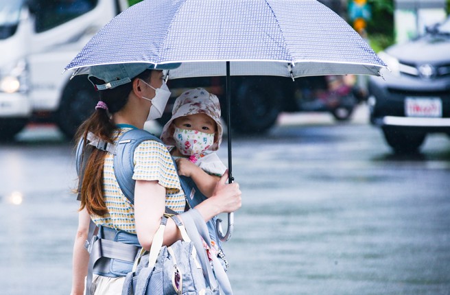  轩岚诺转弱后又增强，不排除重返强颱。民眾外出已备妥雨具。（罗永铭摄）