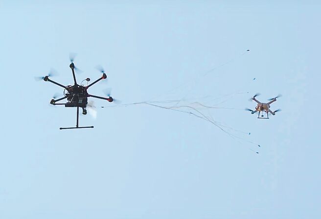 無人空拍機入侵機場影響飛航安全案例頻傳，中科院研發國內第一套無人機防禦系統（UAV Defense System, UDS）開發，可以干擾並捕捉無人機，也可依照需求客製化，以維飛安與軍機保密。圖為「捕捉機」（左）射出網子，捕獲「入侵機」。（中科院提供）
