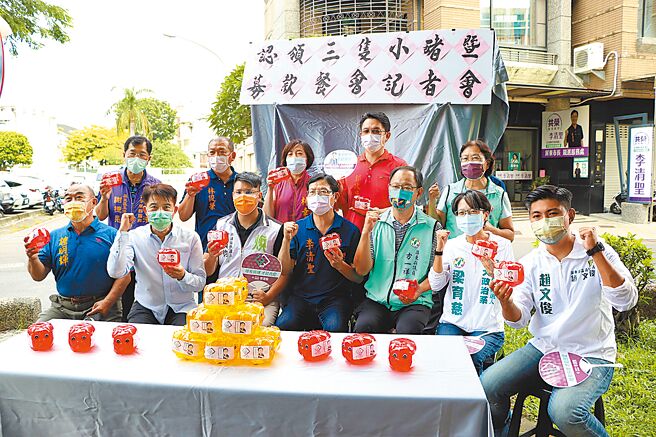 民进党籍屏东市长参选人李清圣（前排中）1日以「支持清廉、拒绝贪污」推出3只小猪扑满募款，并公开呛劲敌国民党籍周佳琪，坐拥议长之女政二代身分大气粗。（谢佳潾摄）