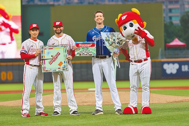 富邦悍将洋投罗力（右二）育定在今日迎来生涯最终战，昨日赛前味全龙由队长吴东融献上花束、好友伍铎则送上特制桌游。（味全龙提供）