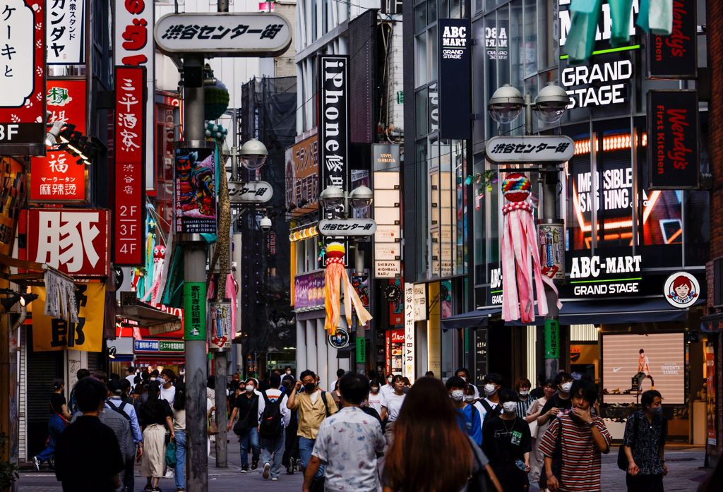 戴著防護口罩的路人走在澀谷購物和娛樂區的街道資料照。（路透社）