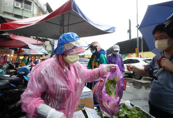 轩岚诺颱风进逼，部分菜价受到影响纷纷上涨。不少民眾穿着雨衣冒雨前往传统市场购买民生用的蔬菜。（刘宗龙摄）