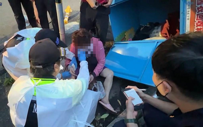 妇人脱困后，在马路边休息一段时间，才自行骑车离去。（读者提供／陈彩玲基隆传真）