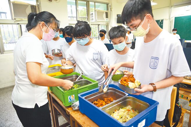 台北市怀生国中老师1日中午在教室内分配营养午餐给学生。（张铠乙摄）