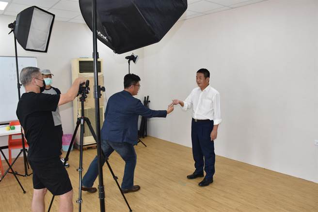 民进党提名苗栗县长参选人徐定祯，7日在头份市竞选总部拍定装照，竞总执行长郑宏辉助调整姿势动作。（谢明俊摄）
