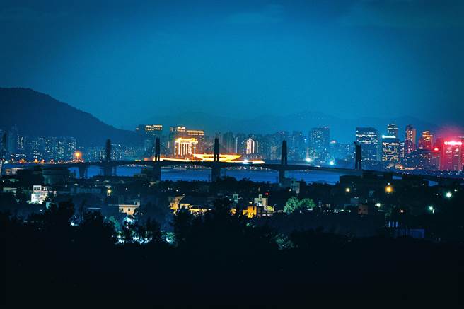 金门大桥即将于10月完工通车，县府规画3大亮点的国际级点灯活动。大桥背景即为灯火通明的厦门。（金门县府摄影官薛子轩提供）