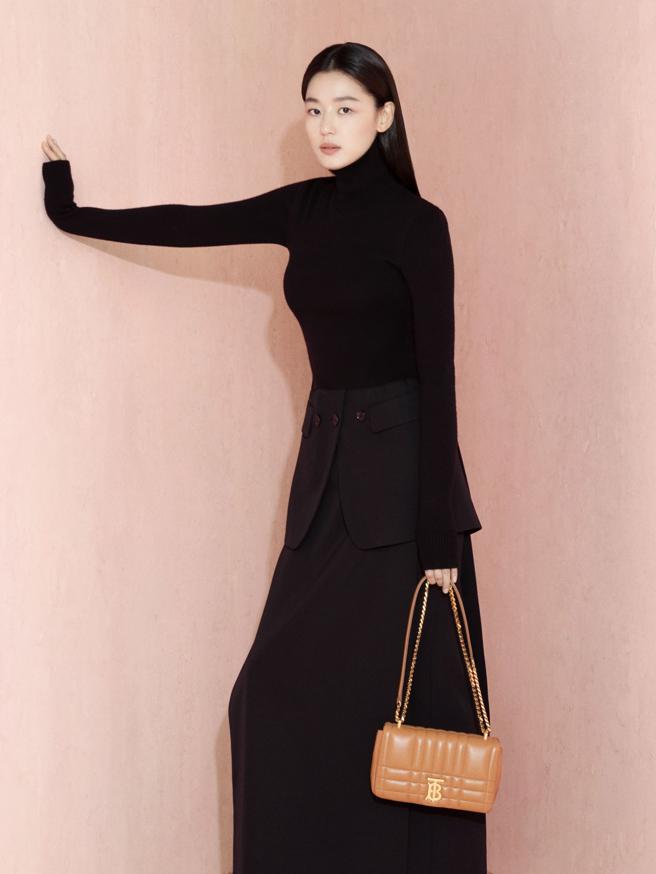 全智贤以黑色喀什米尔高领毛衣和黑色细致羊毛裙，搭配绗缝真皮 Lola包。（BURBERRY提供）