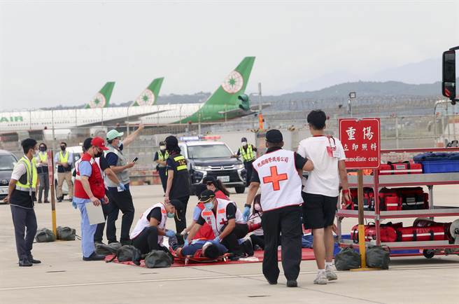 桃园机场公司为强化机场空难防救灾能力，7日下午在804、805外机坪举办「111 年度空难灾害防救演习」实兵演练。消防人员将伤患搬运送至检伤区。（陈麒全摄）