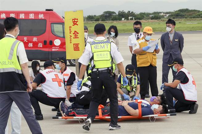桃园机场公司为强化机场空难防救灾能力，7日下午在804、805外机坪举办「111 年度空难灾害防救演习」实兵演练。消防人员将伤患搬运送至检伤区。（陈麒全摄）