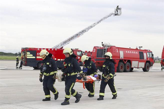 桃园机场公司为强化机场空难防救灾能力，7日下午在804、805外机坪举办「111 年度空难灾害防救演习」实兵演练。消防人员将伤患搬运出。（陈麒全摄）