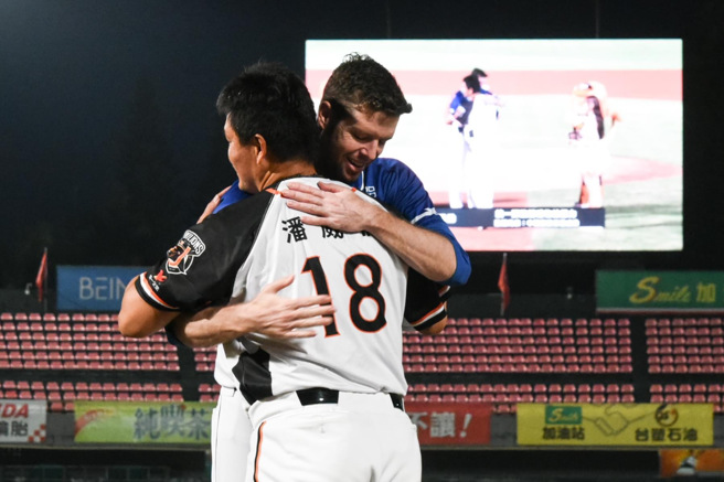 罗力（后）拥抱狮队投手潘威伦。（统一狮提供）
