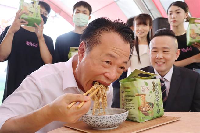 嘉义县长翁章梁大口品尝乌龙茶拌麵的滋味，直夸好吃。（吕妍庭摄）