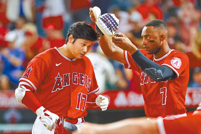 大谷翔平（左）在3局下敲出本季第31轰，回到休息室队友阿戴尔帮他戴上庆祝全垒打的牛仔帽。（美联社）