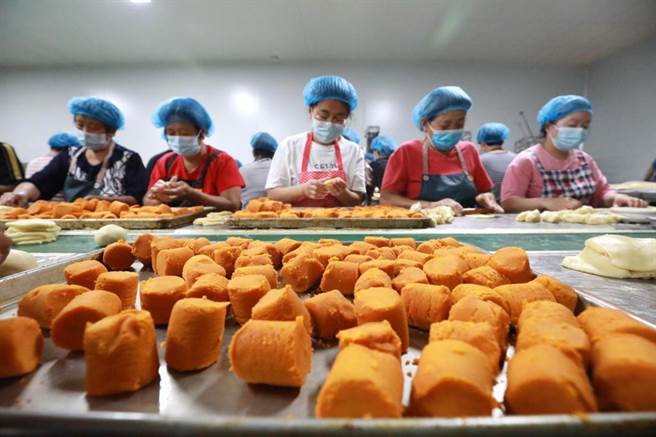 大陆多地宣导就地过中秋，导致大陆国内航线平均机票价出现下降。图为大陆河北石家庄的工人正在制作月饼。（资料照／新华社）